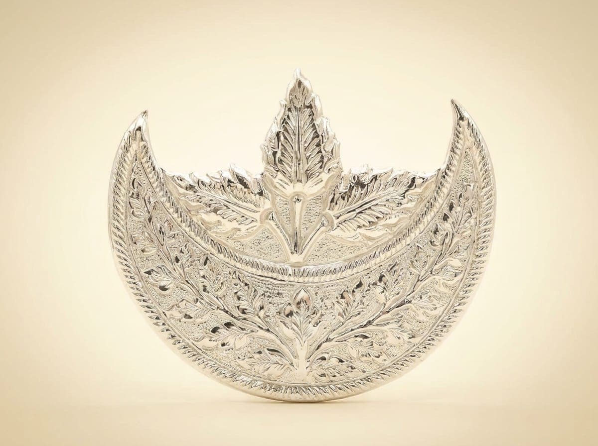 Single polished silver crown for a murti with a curved engraved band, pointed ends and upright central leaf crest